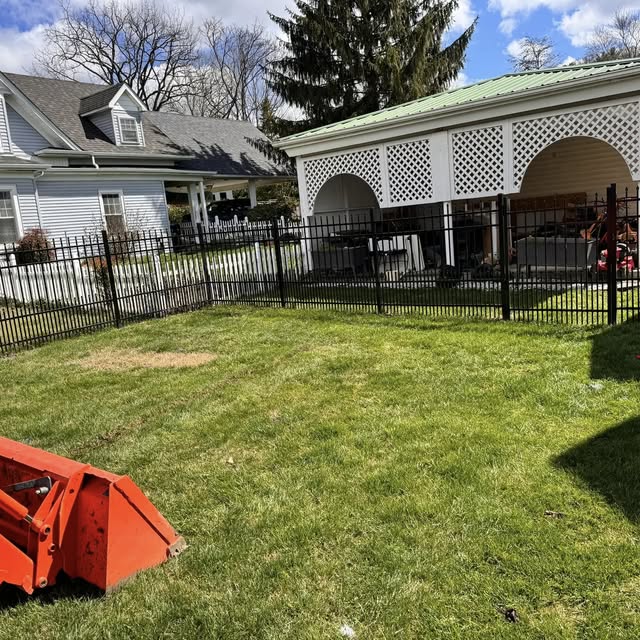 Freshly mowed, fully fenced backyard next to a covered porch